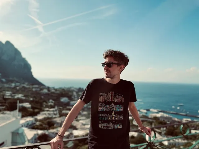 Tommy Carpi on a terrace above Capri, with the sea behind him